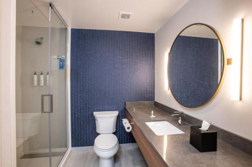 a bathroom with a toilet and a sink and a mirror at Fairfield by Marriott Inn & Suites Newport Cincinnati in Newport