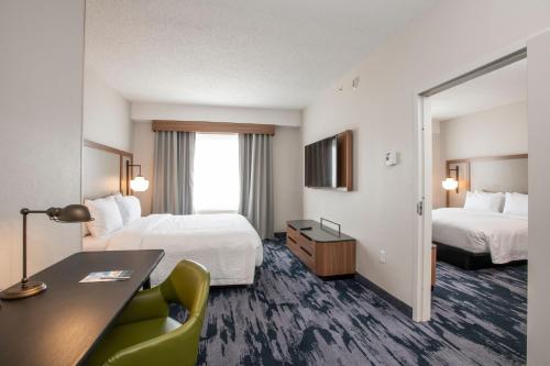 a hotel room with two beds and a desk at Fairfield by Marriott Inn & Suites Newport Cincinnati in Newport