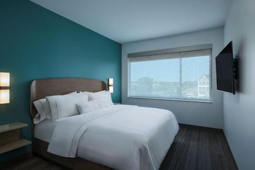 a bedroom with a large white bed and a window at Element Waco in Waco