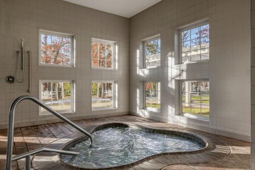 uma casa de banho com banheira de hidromassagem num quarto com janelas em Marriott's Fairway Villas em Galloway