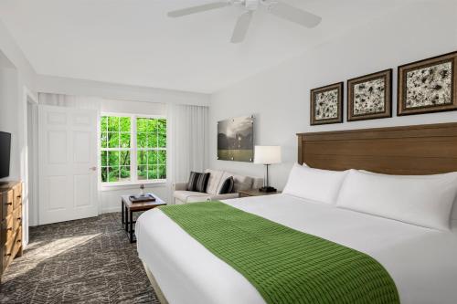a bedroom with a large bed with a green blanket at Marriott's Fairway Villas in Galloway