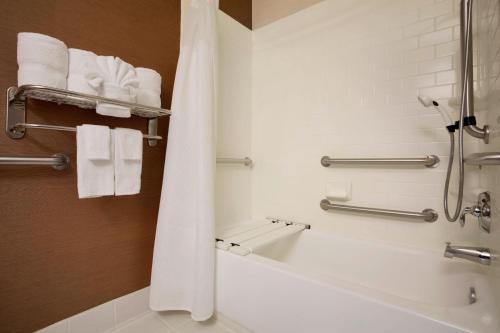 a bathroom with a tub and a shower with towels at Fairfield Inn & Suites Fort Worth University Drive in Fort Worth