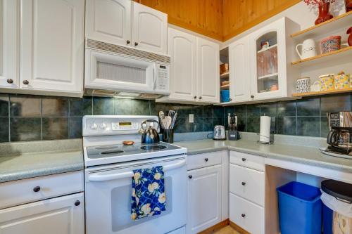 a kitchen with white cabinets and a white stove top oven at Leavenworth Cabin with Private Hot Tub! in Leavenworth