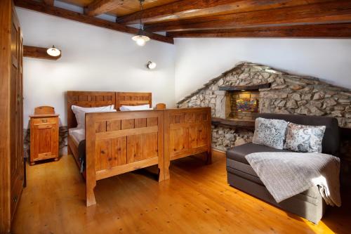 a bedroom with a bed and a stone fireplace at Holiday Home Oliti with Pool in Mošćenice