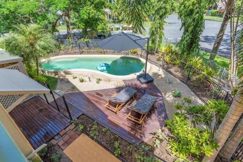 an overhead view of a swimming pool with two chairs and an umbrella at Casa De Playa - Beach Townhouse in Holloways Beach