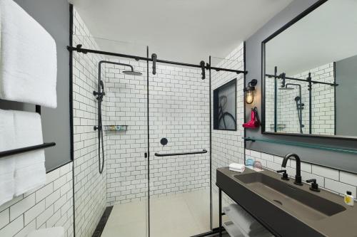 a bathroom with a glass shower and a sink at Moxy Nanjing Jiangning in Nanjing