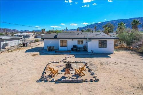 a house in the middle of a dirt yard with a house at Cozy Fresh Desert Hideaway, 5 mins to Joshua Tree in Twentynine Palms