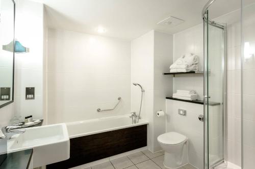 ein Badezimmer mit einer Badewanne, einem WC und einem Waschbecken in der Unterkunft Delta Hotels by Marriott Nottingham Belfry in Nottingham