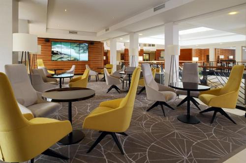 a restaurant with yellow chairs and tables and chairs at Cologne Marriott Hotel in Cologne