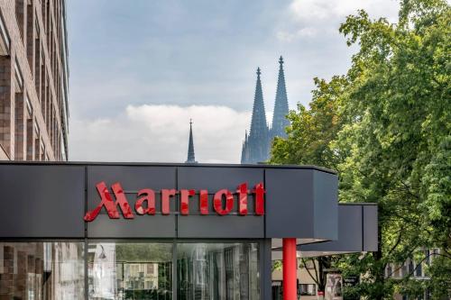 een Marriott bord voor een gebouw met bomen bij Cologne Marriott Hotel in Keulen