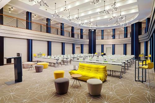 a large banquet hall with tables and yellow chairs at Cologne Marriott Hotel in Cologne