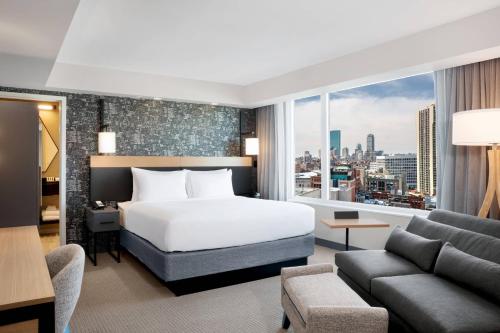a hotel room with a bed and a large window at Courtyard Boston Downtown/North Station in Boston