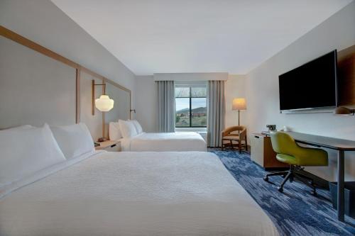 a hotel room with two beds and a desk at Fairfield by Marriott Inn & Suites Denver Southwest, Littleton in Littleton