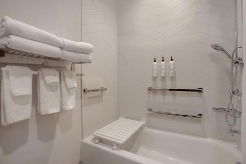 ein weißes Bad mit einer Dusche, einer Badewanne und Handtüchern in der Unterkunft Fairfield by Marriott Inn & Suites Denver Southwest, Littleton in Littleton