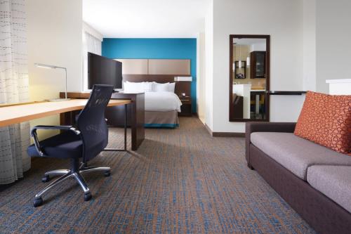 a hotel room with a desk and a couch and a bed at Residence Inn by Marriott Houston Pasadena in Pasadena