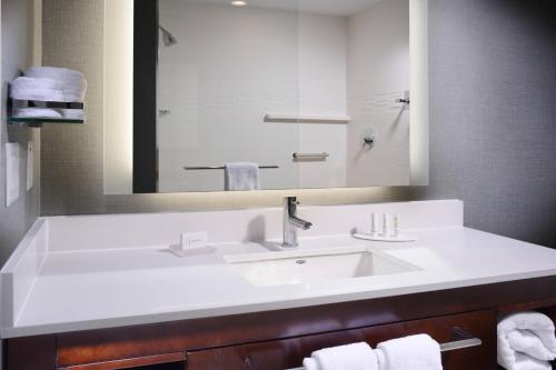 a bathroom with a sink and a mirror and towels at Residence Inn by Marriott Houston Pasadena in Pasadena