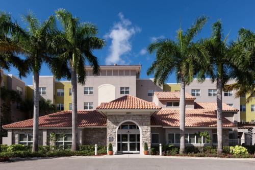 um edifício com palmeiras em frente em Residence Inn by Marriott Fort Lauderdale Airport & Cruise Port em Dania Beach