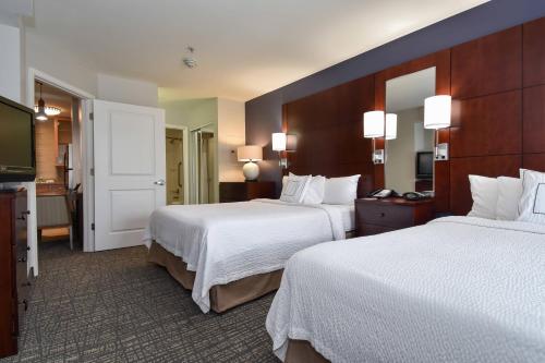 Cette chambre comprend deux lits et une télévision. dans l'établissement Residence Inn Charlotte Concord, à Concord