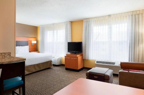 a hotel room with a bed and a television at TownePlace Suites by Marriott Chicago Naperville in Naperville