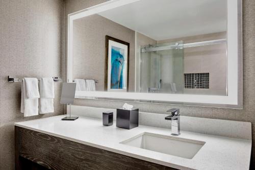 a bathroom with a sink and a large mirror at Ventura Beach Marriott in Ventura