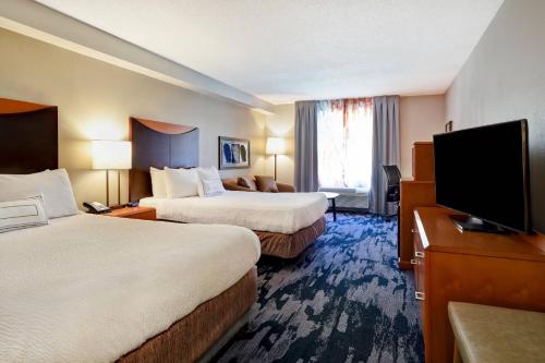 a hotel room with two beds and a flat screen tv at Fairfield Inn & Suites by Marriott Atlanta Kennesaw in Kennesaw