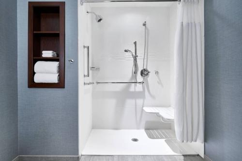 a white bathroom with a shower and a sink at Residence Inn by Marriott Wilmington Downtown in Wilmington