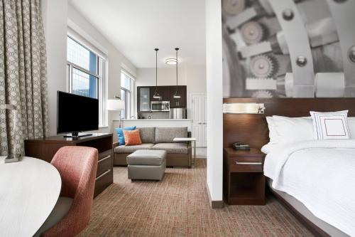 a hotel room with a bed and a living room at Residence Inn by Marriott Wilmington Downtown in Wilmington