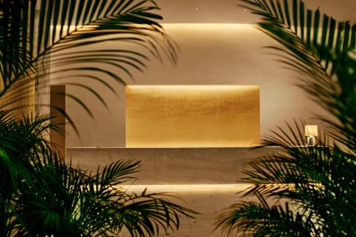 a large light on a wall with plants at The Miami Beach EDITION in Miami Beach