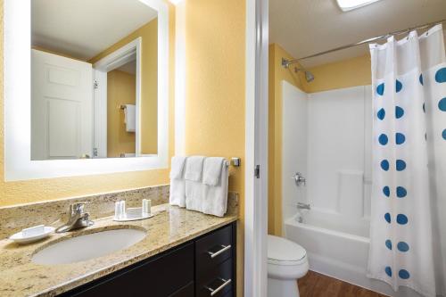 a bathroom with a sink and a toilet and a mirror at TownePlace Suites Los Angeles LAX Manhattan Beach in Hawthorne