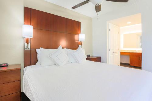 Residence Inn by Marriott Atlanta Cumberland/Galleria في أتلانتا: غرفة نوم بسرير ابيض كبير مع مخدات بيضاء