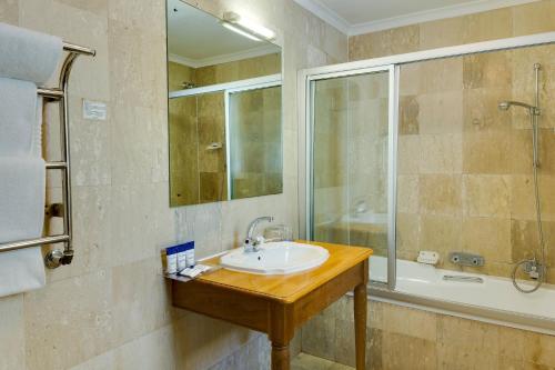 a bathroom with a sink and a shower at Protea Hotel by Marriott Dorpshuis & Spa Stellenbosch in Stellenbosch