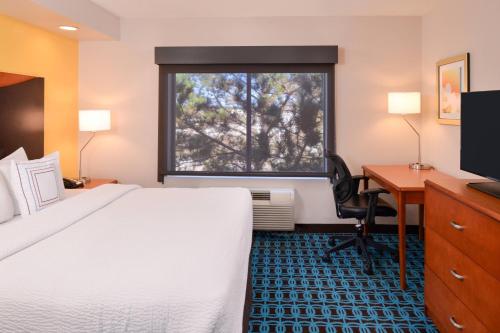 um quarto de hotel com uma cama, uma secretária e uma janela em Fairfield Inn & Suites Hattiesburg / University em Hattiesburg