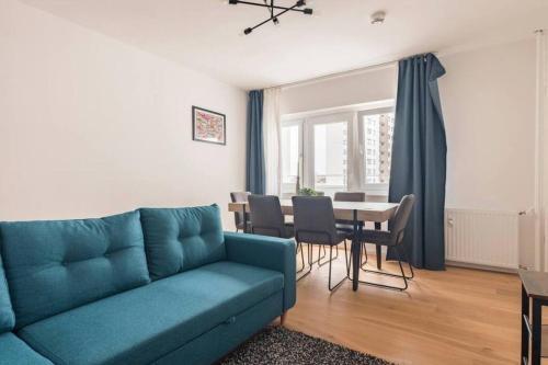 un soggiorno con divano blu e tavolo di Modern Home in Central Berlin a Berlino