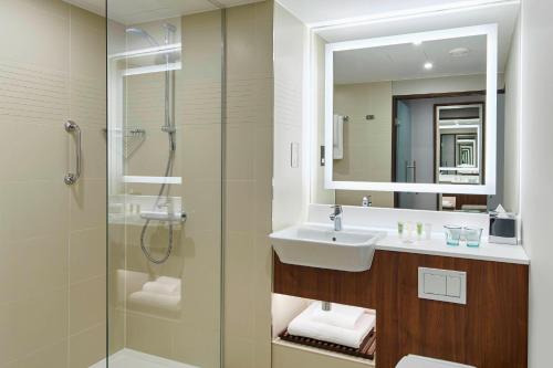 a bathroom with a sink and a shower at Courtyard by Marriott Luton Airport in Luton