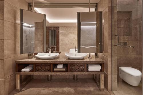 Baño con 2 lavabos y espejo en Renaissance Dhaka Gulshan Hotel, en Dhaka