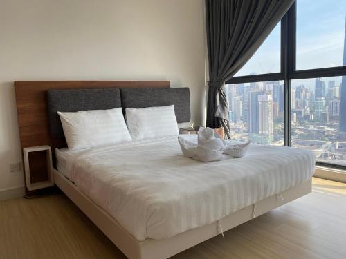 a bedroom with a large bed with a large window at Infini Suites@ Continew Residence KL in Kuala Lumpur