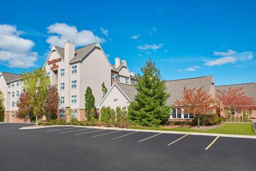 a large white building with a parking lot at Residence Inn by Marriott Detroit / Novi in Novi