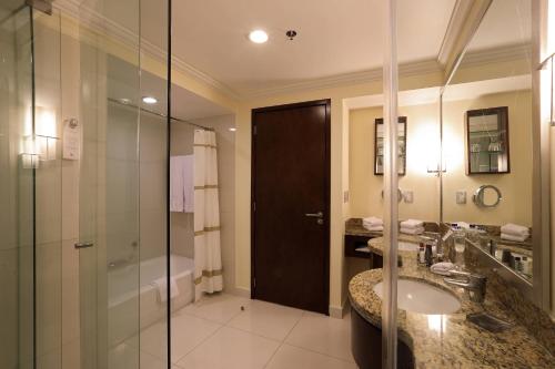 baño con ducha, lavabo y puerta de cristal en Aguascalientes Marriott Hotel, en Aguascalientes