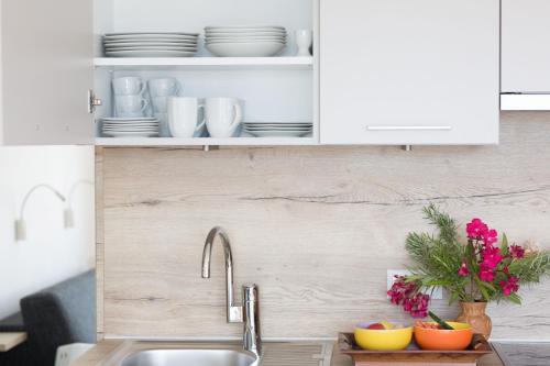 a kitchen counter with a sink and white cabinets at Appartements Martinsheim in Tirolo