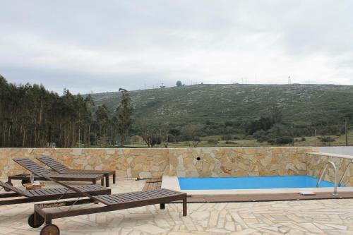 a patio with two benches and a swimming pool at Pro Touristic Montejunto Villas in Arieiro