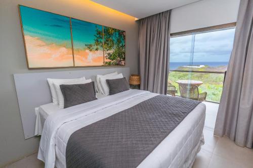 a bedroom with a large bed and a large window at Miragem Noronha in Fernando de Noronha