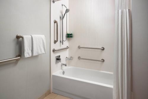 a white bathroom with a tub and a shower at Courtyard by Marriott Fayetteville in Fayetteville