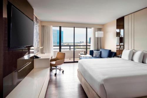 um quarto de hotel com uma cama grande e uma televisão de ecrã plano em Irvine Marriott em Irvine