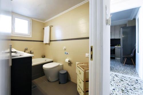 a bathroom with a toilet and a sink and a tub at Aspasia's Fresh House in Adamas