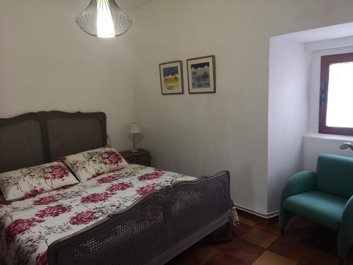 a bedroom with a bed and a blue chair at Casa rural Ardetxal a 16km de Logroño y Laguardia in Viñaspre