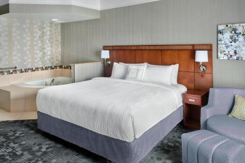 a hotel room with a bed and a bath tub at Courtyard by Marriott Paramus in Paramus