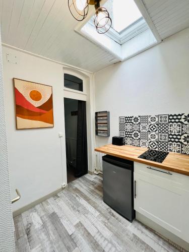 une cuisine avec un comptoir et une fenêtre dans l'établissement L’escale proche centre ville, à Amiens