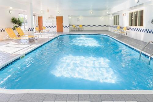 Fairfield Inn & Suites Grand Rapids في غراند رابيدز: مسبح كبير مع ماء أزرق في غرفة الفندق