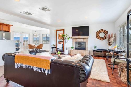 a living room with a leather couch and a fireplace at The Castle House Estate in Joshua Tree
