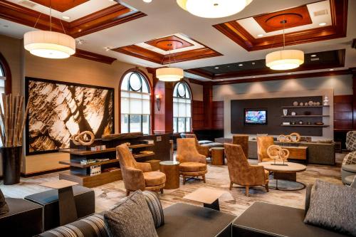 a lobby with a waiting room with chairs and tables at Courtyard by Marriott Norfolk Downtown in Norfolk